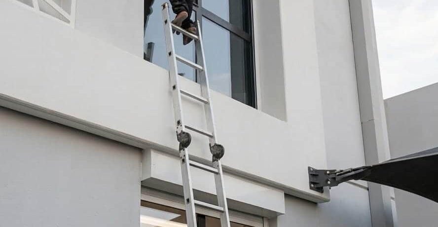 عمال مؤسسة كم النظافة أثناء تلميع واجهات زجاجية بالرياض