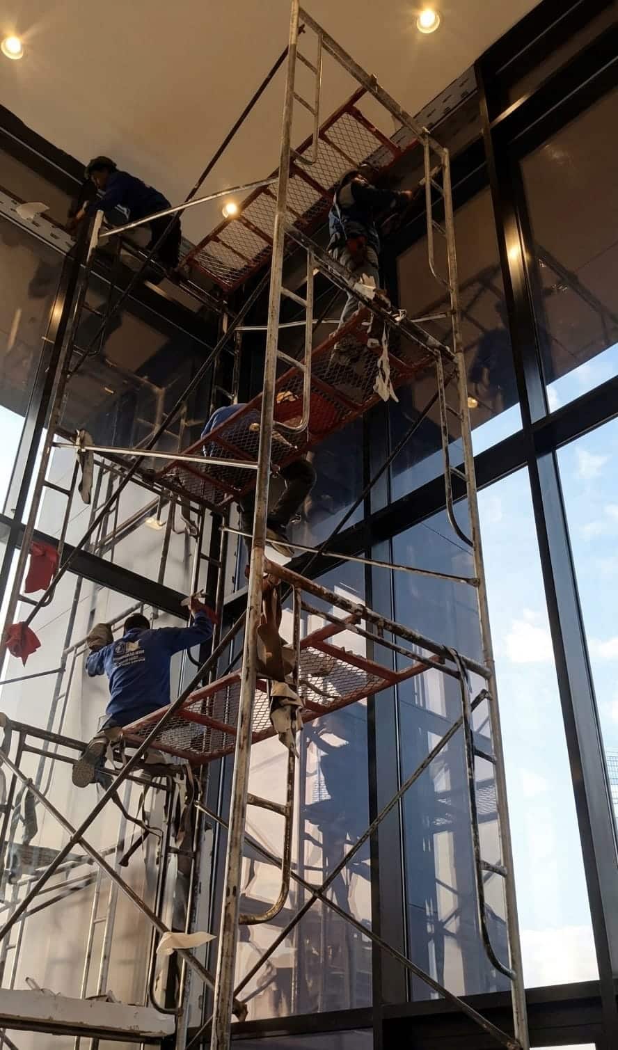 فريق عمل متخصص في تنظيف وتلميع واجهات زجاجية للمباني والشركات بالرياض بأعلى معايير الأمان